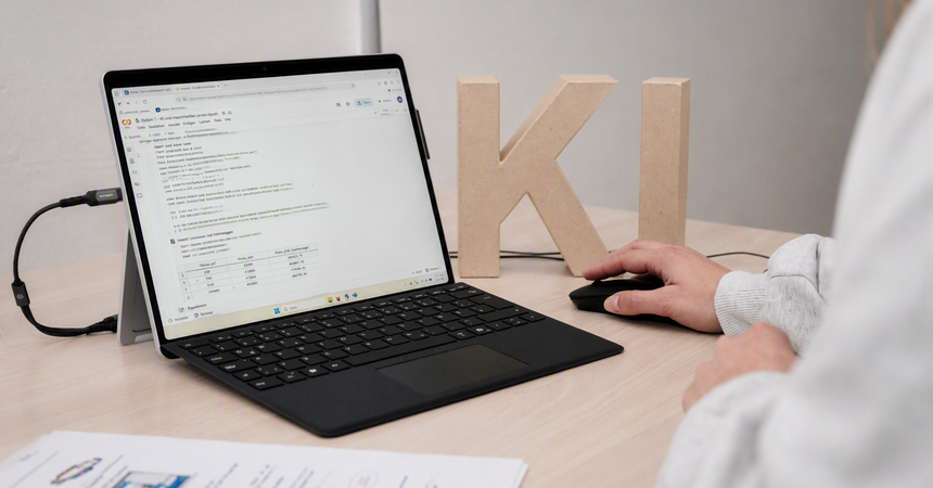 Person arbeitet an einem Laptop mit Programmcode um ein Verstädnis für eine KI-Anwendung zu gewinnen.