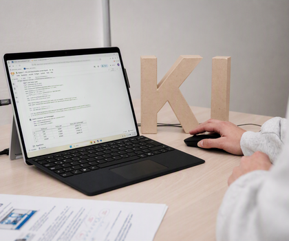 Person arbeitet an einem Laptop mit Programmcode um ein Verstädnis für eine KI-Anwendung zu gewinnen.